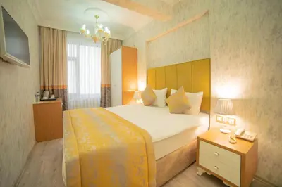 a hotel room with a large bed and a chandelier at Istanbul Old City Sultanahmed Miran Hotel in Istanbul