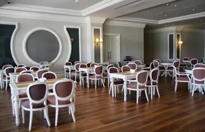 a room with tables and chairs and a mirror at Vialand Palace Hotel in Istanbul