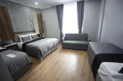 a hotel room with two beds and a chair at Yuvam Vari Hotel in Istanbul