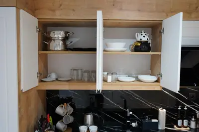 a kitchen with wooden cabinets with dishes and utensils at Adgsuites in Istanbul