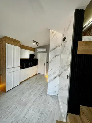 a large kitchen with white cabinets and marble floors at Adgsuites in Istanbul