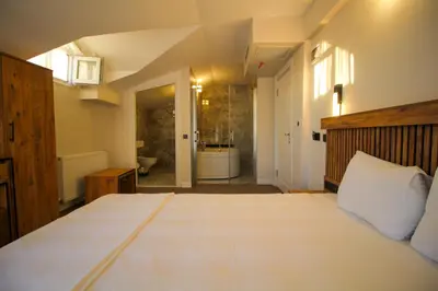 a bedroom with a large bed and a bathroom at Kaya Hotel SAW in Istanbul