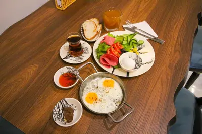 a table with plates of food with eggs and vegetables at Kaya Hotel SAW in Istanbul