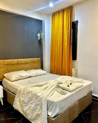 a bed in a room with a yellow curtain at happy apart hotel istanbul in Istanbul