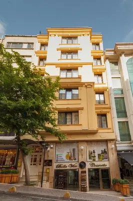 a tall yellow building with windows on a street at Istanbul Old City Beyazid Belmond Hotel in Istanbul