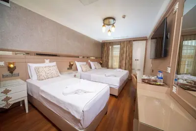 a hotel room with two beds and a television at Istanbul Old City Beyazid Belmond Hotel in Istanbul