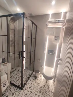 a bathroom with a shower and a toilet with lights at Mara Oldcity Hotel in Istanbul