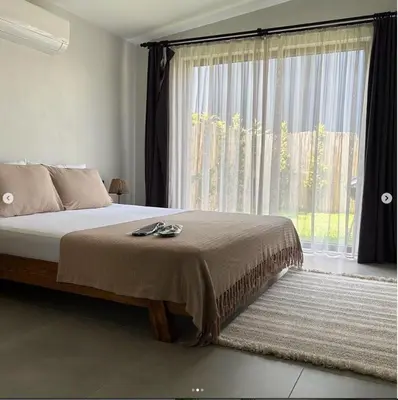 a bedroom with a bed with a large window at Vital Home Sapanca Isıtmalı Havuzlu Villa&Bungalov in Sapanca