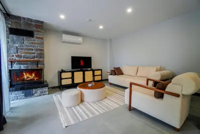 a living room with a couch and a fireplace at Vital Home Sapanca Isıtmalı Havuzlu Villa&Bungalov in Sapanca
