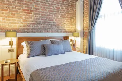 a bedroom with a bed with a brick wall at Hotel Miniature Istanbul in Istanbul