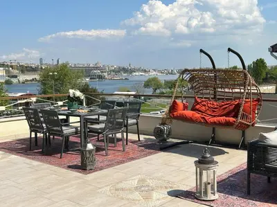 a patio with a table and chairs and a swing at Waterfront Villa by the Tram - Private Terrace with Dome & Golden Horn View in Fatih in Istanbul