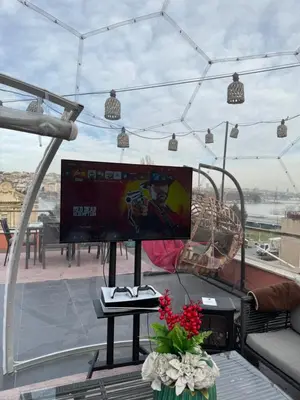 a balcony with a tv and a table with flowers at Waterfront Villa by the Tram - Private Terrace with Dome & Golden Horn View in Fatih in Istanbul
