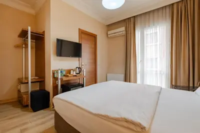 a bedroom with a large white bed and a television at Sisli MLS Hotel in Istanbul