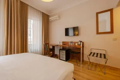 a hotel room with a bed and a desk and a table at Sisli MLS Hotel in Istanbul