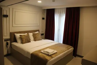 a bedroom with a large bed with red curtains at Eyüp Sultan Palace Hotel in Istanbul