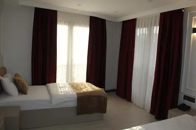 a bedroom with a bed with red curtains and a window at Eyüp Sultan Palace Hotel in Istanbul
