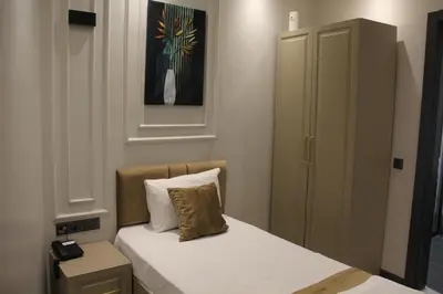 a small bedroom with a bed and a cabinet at Eyüp Sultan Palace Hotel in Istanbul
