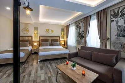 a hotel room with two beds and a couch at LINNGA HOTEL & SUITE in Istanbul