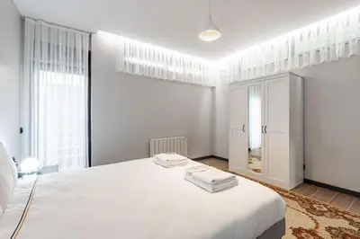 a white bedroom with a large white bed and windows at Brand New Duplex wParking 2BD2Bath Home #336 in Istanbul