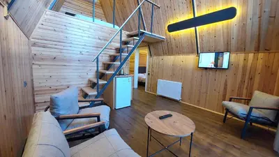 a living room with a couch and a staircase at Patya BUNGALOV in Dereköy