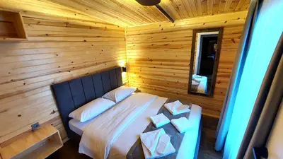 a bedroom with a bed in a wooden room at Patya BUNGALOV in Dereköy