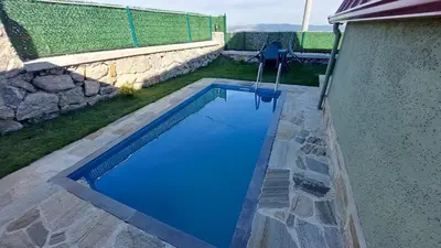 a swimming pool with blue water in a yard at Patya BUNGALOV in Dereköy