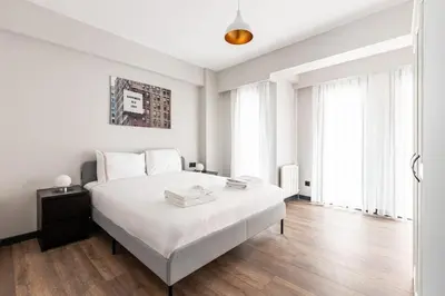 a white bedroom with a large white bed and wooden floors at Cozy Bright wParking 2BD1Bath Central Home!#338 in Istanbul