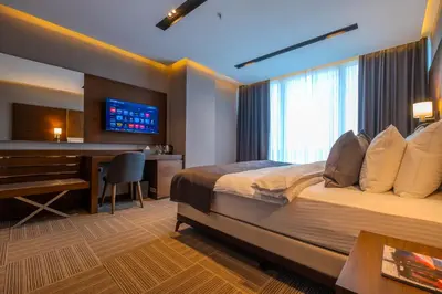 a bedroom with a bed and a desk and a television at B'İSTANBUL HOTEL in Istanbul