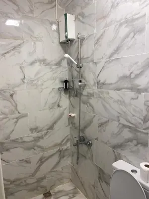 a bathroom with a shower with white marble walls at YENİkapı hotel in Istanbul