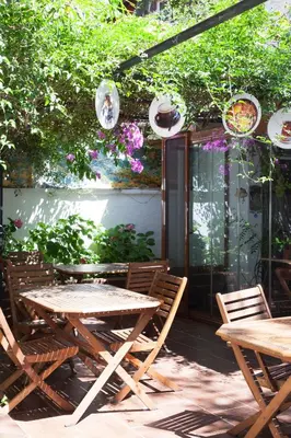 a patio with a table and chairs and flowers at Orhan Kutbayin Evi in Buyukada