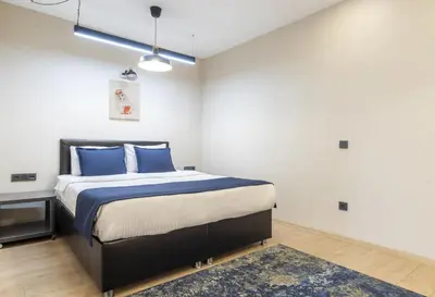 a bedroom with a bed with blue pillows and a rug at The Business Class Suit Karakoy in Istanbul