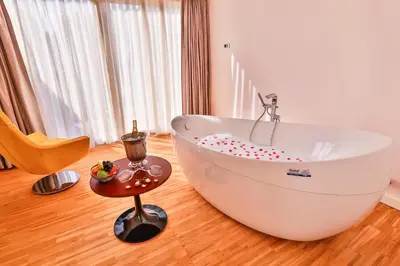 a white bath tub in a room with a table at Business Life Hotel & Spa Şişli in Istanbul