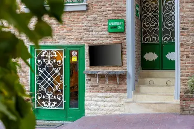 a green door on a brick building with a tv at APARTMENTS BAKRAC 26 in Istanbul