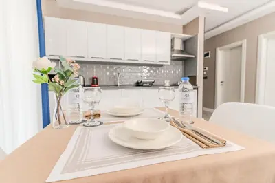 a table with plates and glasses and flowers on it at Olea Suites Otel in Gemlik