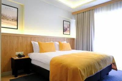 a hotel room with a large bed with yellow pillows at Dugi Hotel in Istanbul