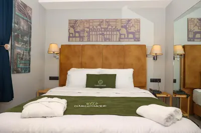 a bedroom with a large bed with two pillows on it at Gardenmode Airport Hotel in Taşoluk
