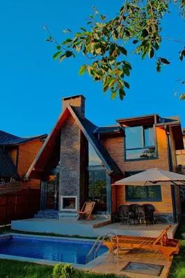 a house with a pool and a patio with an umbrella at Sapanca Grandwooden in Sakarya