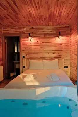 a bedroom with a bed and a bath tub at Sapanca Grandwooden in Sakarya