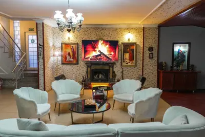 a living room with white chairs and a fireplace at Destina Boutique Hotel Ağva in Sile