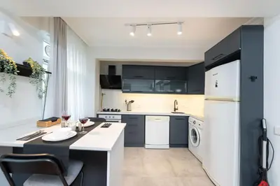 a kitchen with black cabinets and a white refrigerator at G&B MANSION in Istanbul