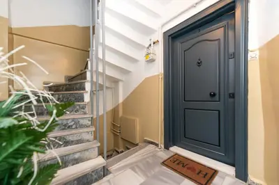 a black door in a hallway with stairs at G&B MANSION in Istanbul