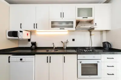 a white kitchen with a sink and a microwave at G&B MANSION in Istanbul