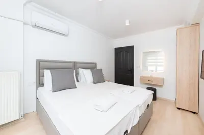a white bedroom with a large bed with white sheets at G&B MANSION in Istanbul