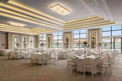 a banquet hall with white tables and chairs and windows at Ramada by Wyndham Karacabey in Bursa