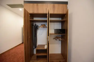 a closet with wooden shelves and an umbrella at Ramada by Wyndham Karacabey in Bursa
