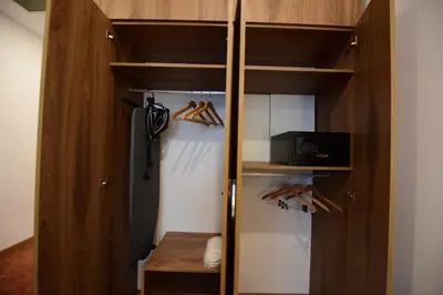 a walk in closet with wooden cabinets and shoes at Ramada by Wyndham Karacabey in Bursa
