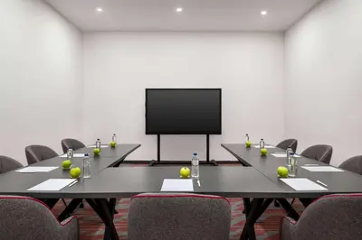 a conference room with two tables and a flat screen tv at Ramada by Wyndham Karacabey in Bursa