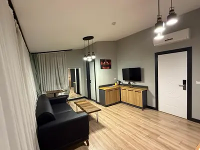 a living room with a black couch and a tv at Taksim Millennium Alkan Residence in Istanbul