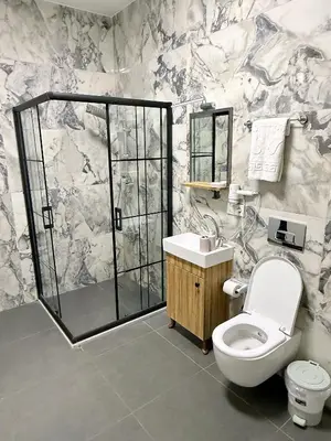 a bathroom with a shower and a toilet and a sink at Taksim Millennium Alkan Residence in Istanbul