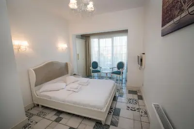 a room with a bed and two chairs and a table at Buyukada Cankaya Hotel in Buyukada